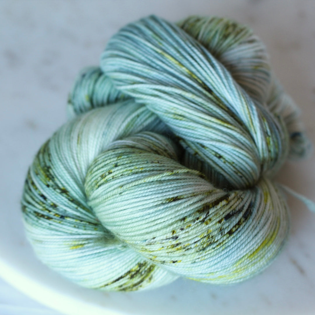 Skein of green and white yarn on a light background