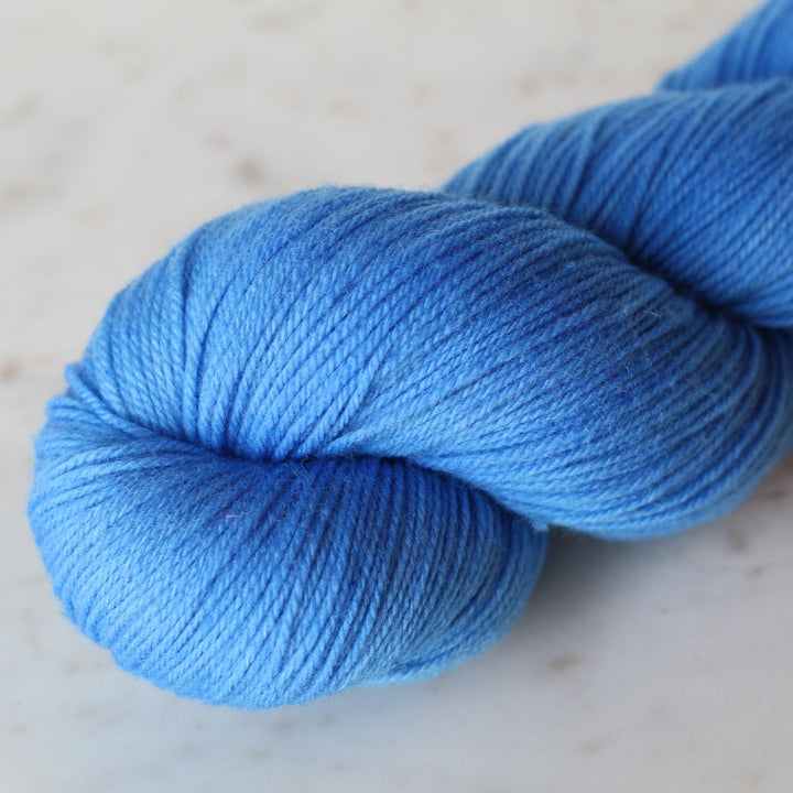 Azure Blue skein of yarn on a light beige background