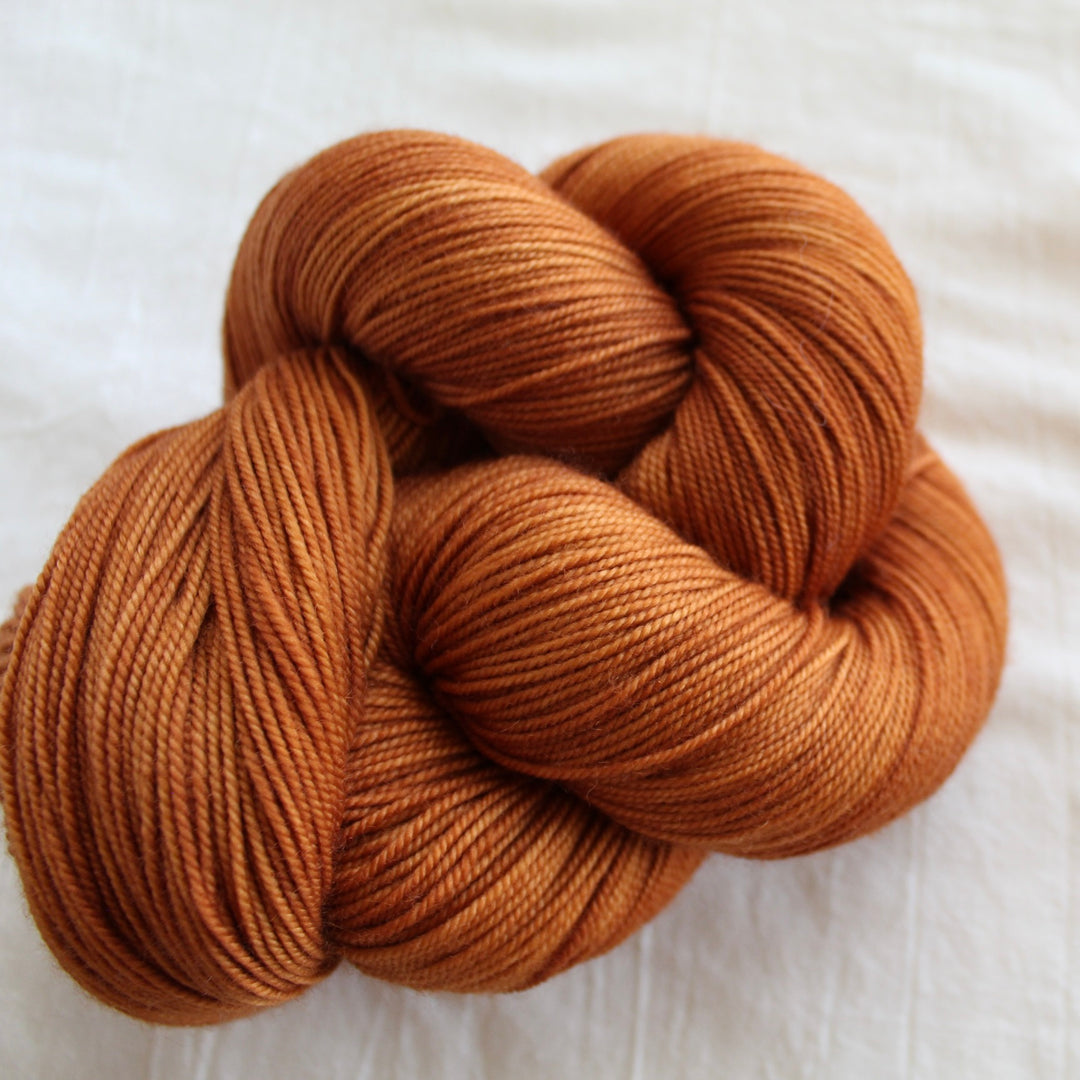 rust golden orange yarn on white fabirc
