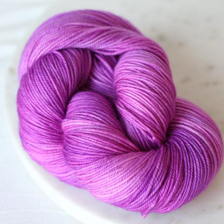 Purple skein of yarn on a light gray background