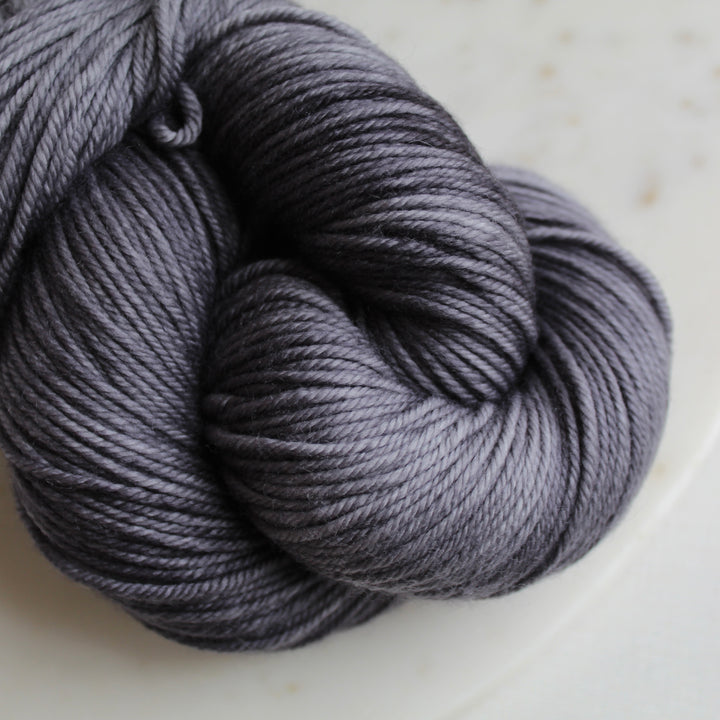 Dark charcoal grey yarn on marble plate