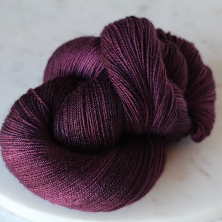 Purple skein of yarn on a marble surface