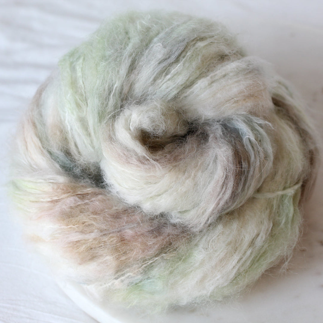 Cream yarn with green and blue washes on marble plate