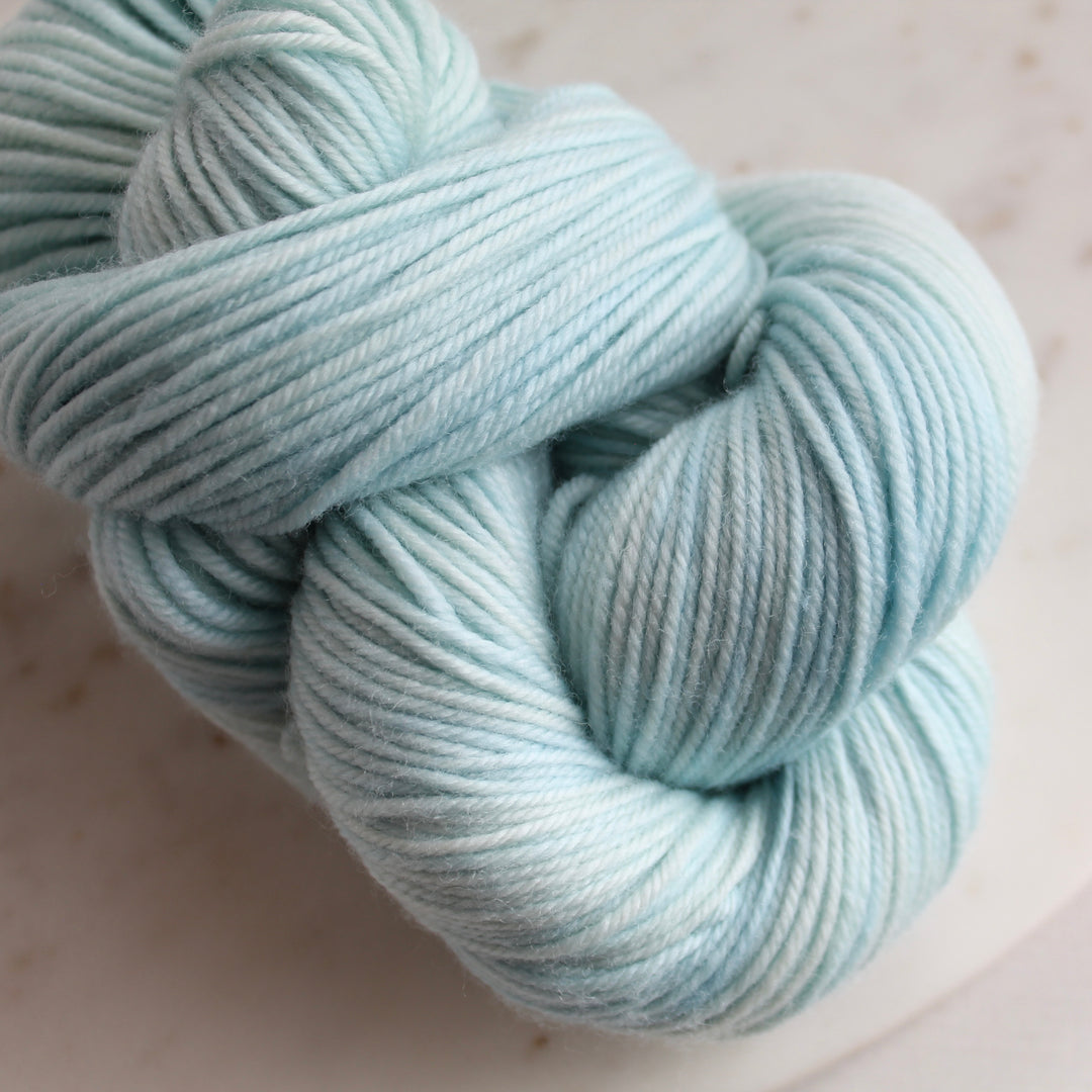 minty blue yarn on white marble plate
