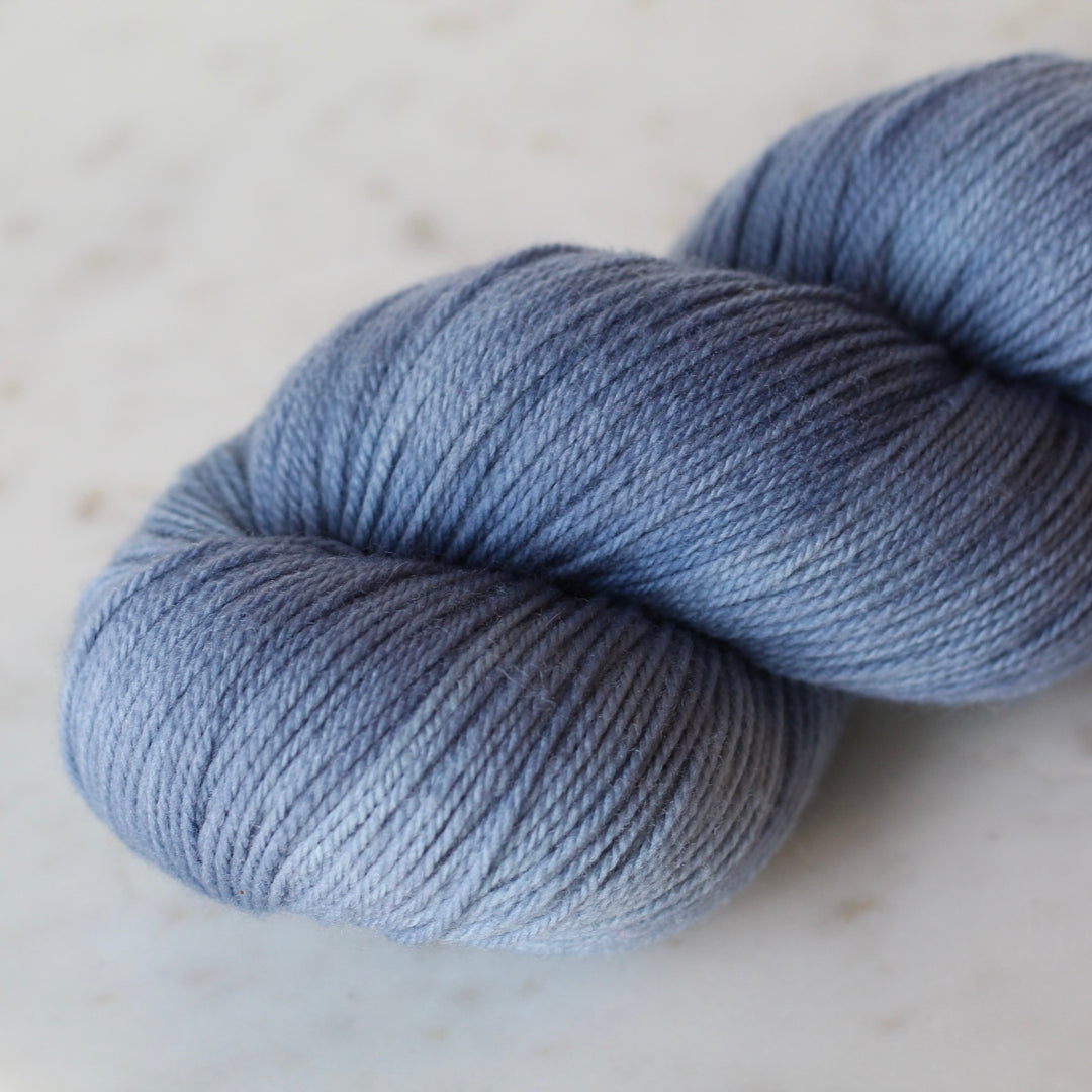 Soft Blue skein of yarn on a light marble background