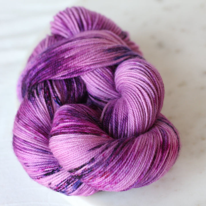 purple speckled skein of yarn on marble 