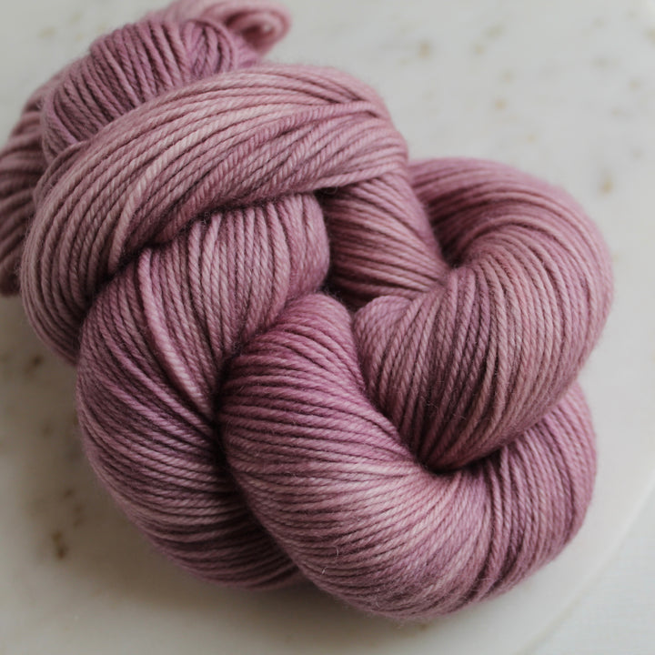 Pink mauve yarn on marble plate