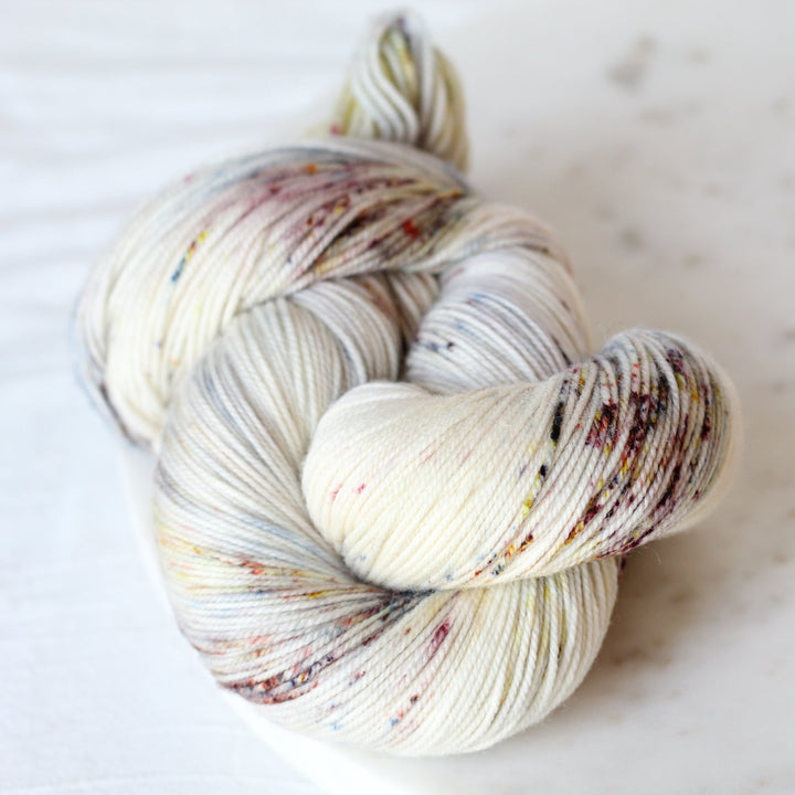 Speckled cream skein of yarn on marble