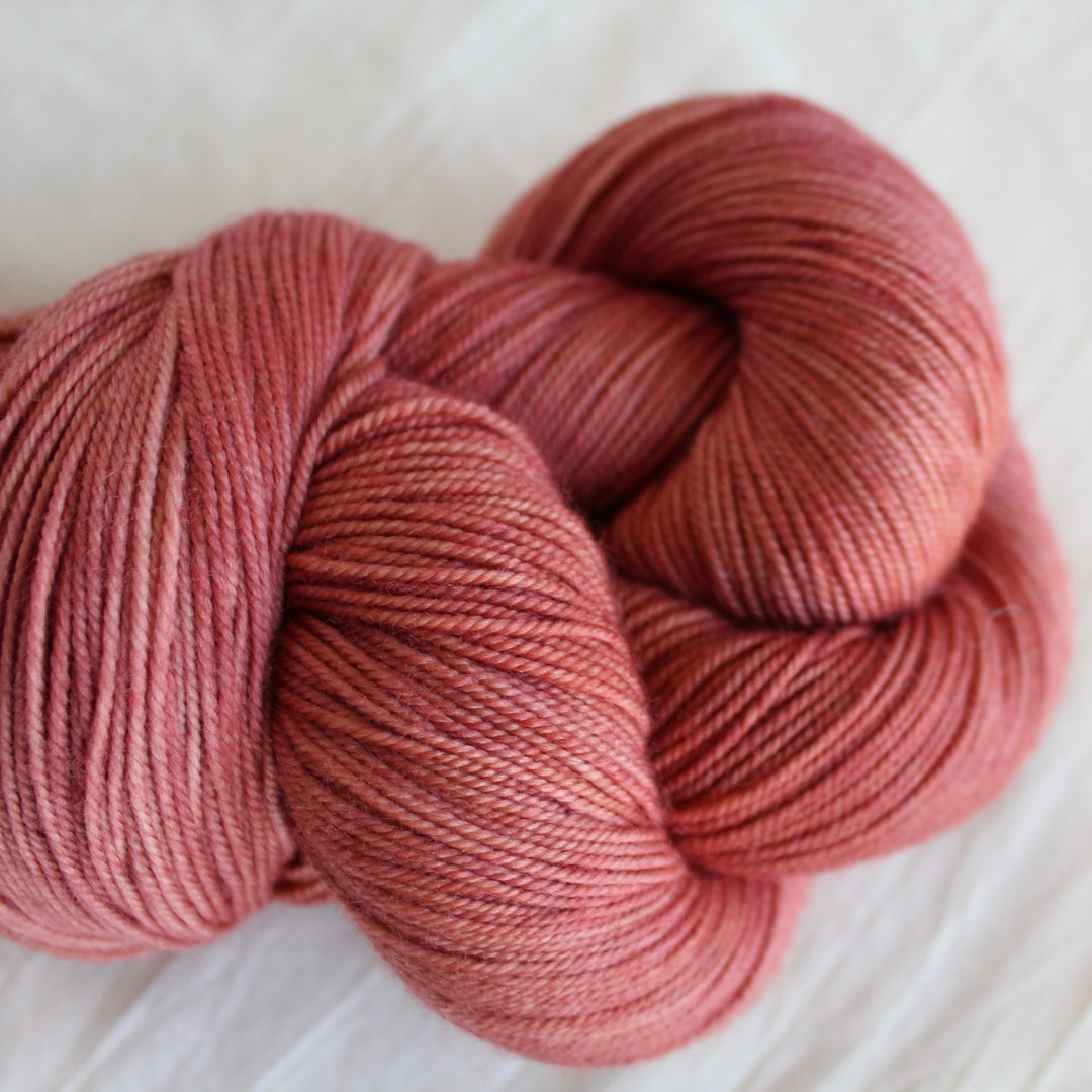 Coral yarn on a white linen fabric