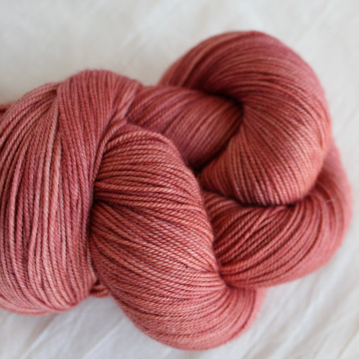 Coral yarn on a white linen fabric