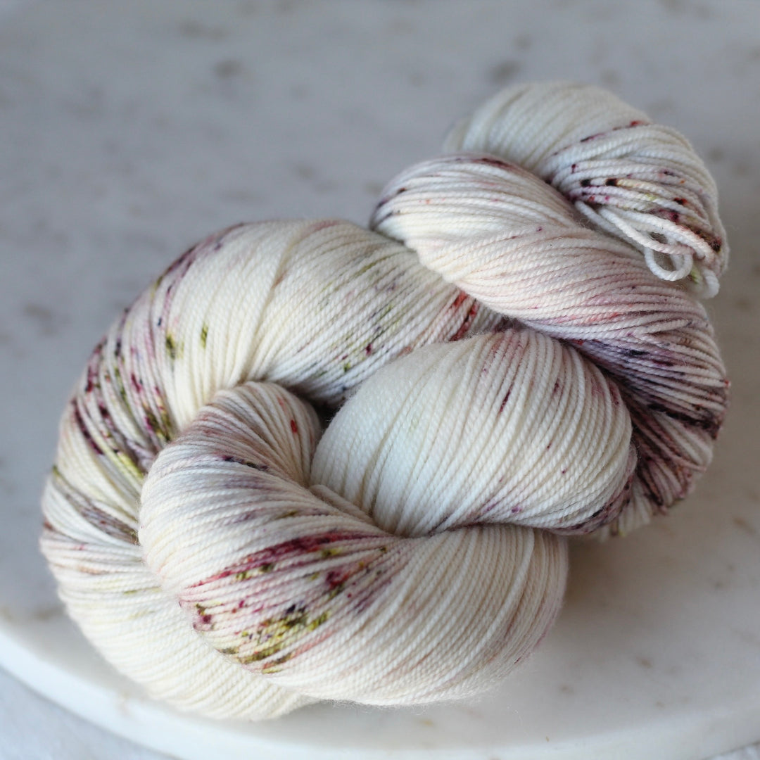White yarn with speckled patterns on a light gray background