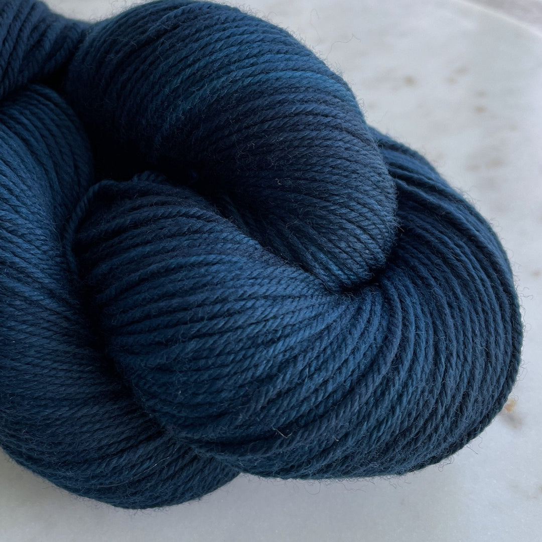 deep teal blue yarn on marble plate