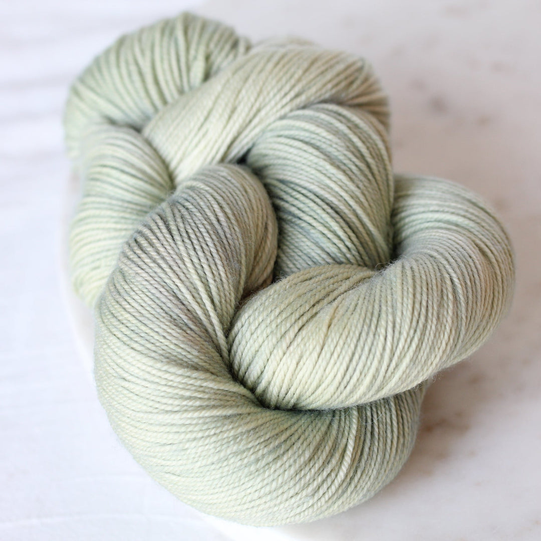 Skein of light green yarn on a white background