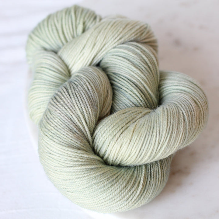 Skein of light green yarn on a white background