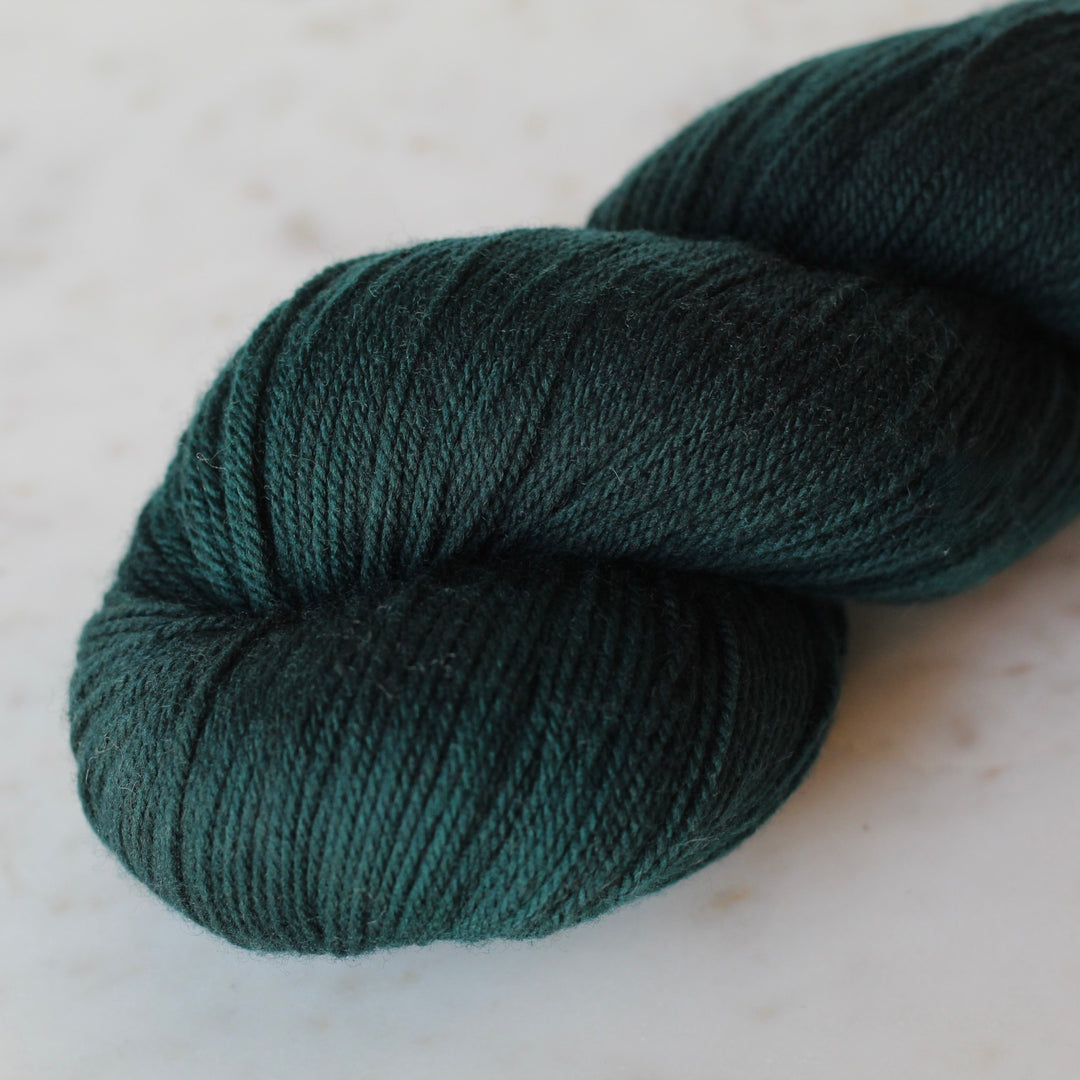 Dark Teal Green skein of yarn on a light background