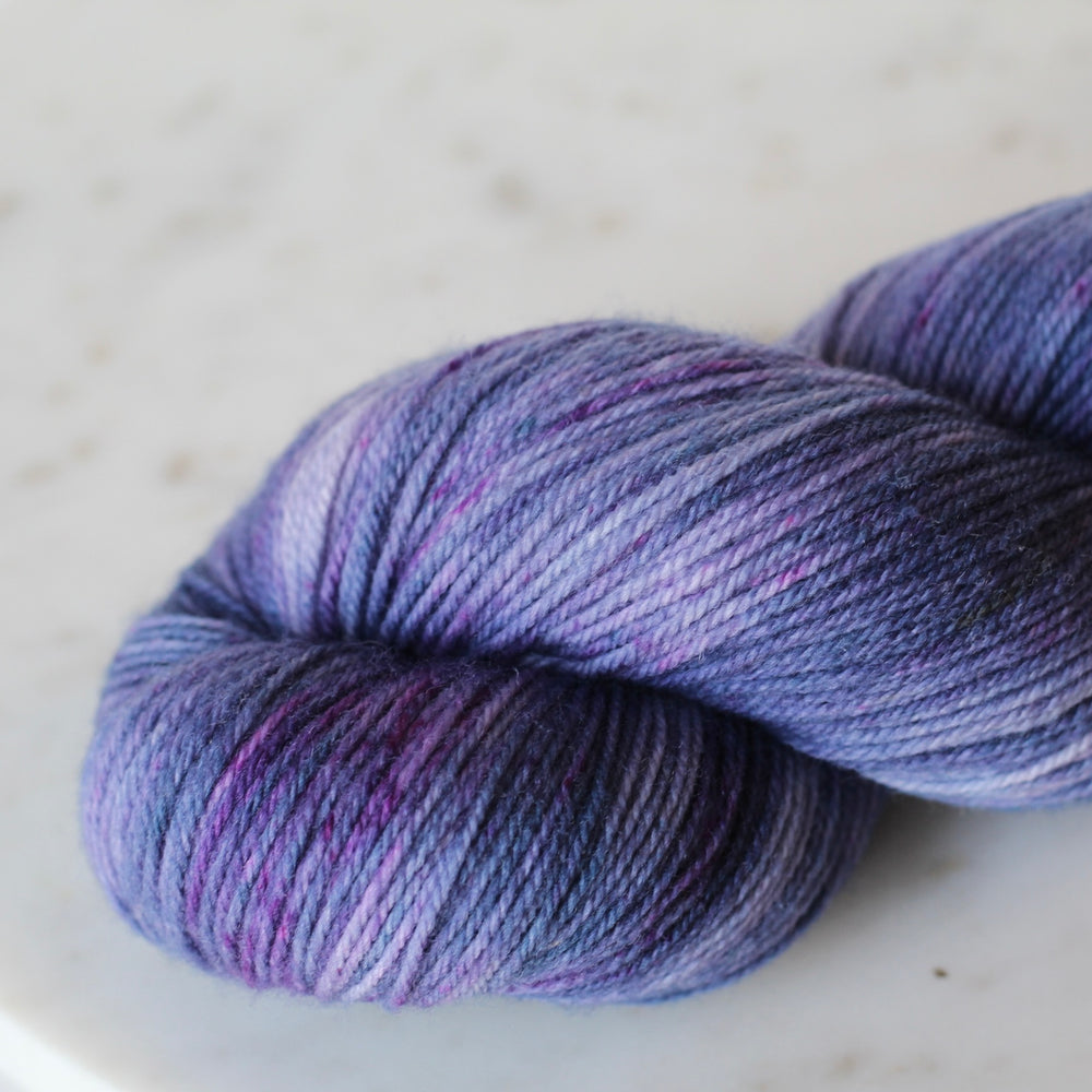 Purple skein of yarn on a light gray background