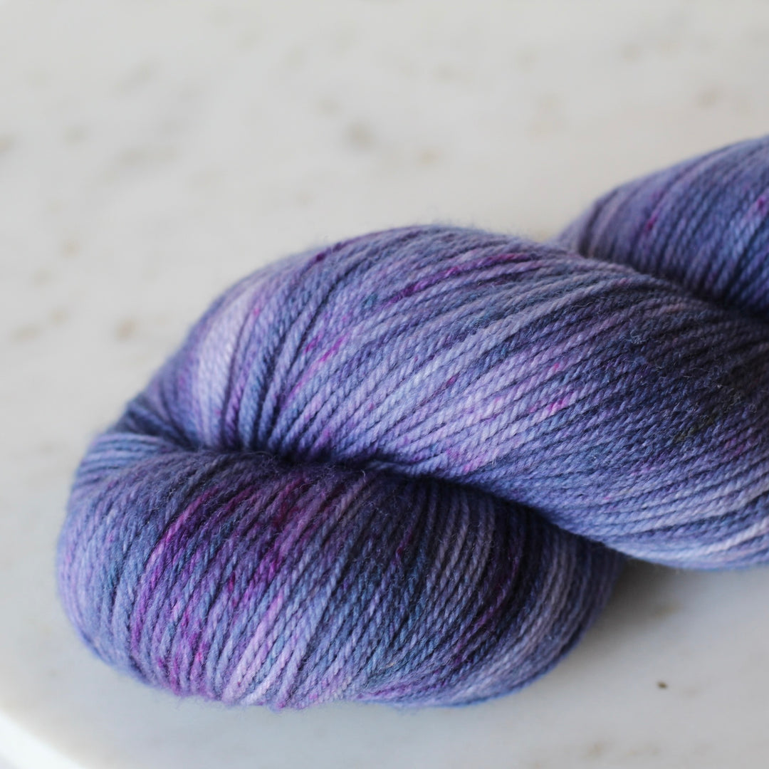 Purple skein of yarn on a light gray background