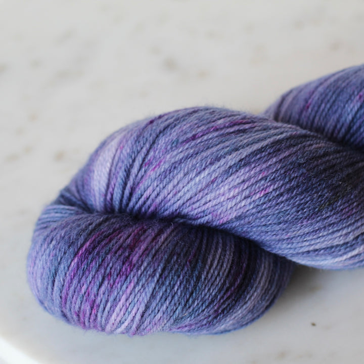 Purple skein of yarn on a light gray background