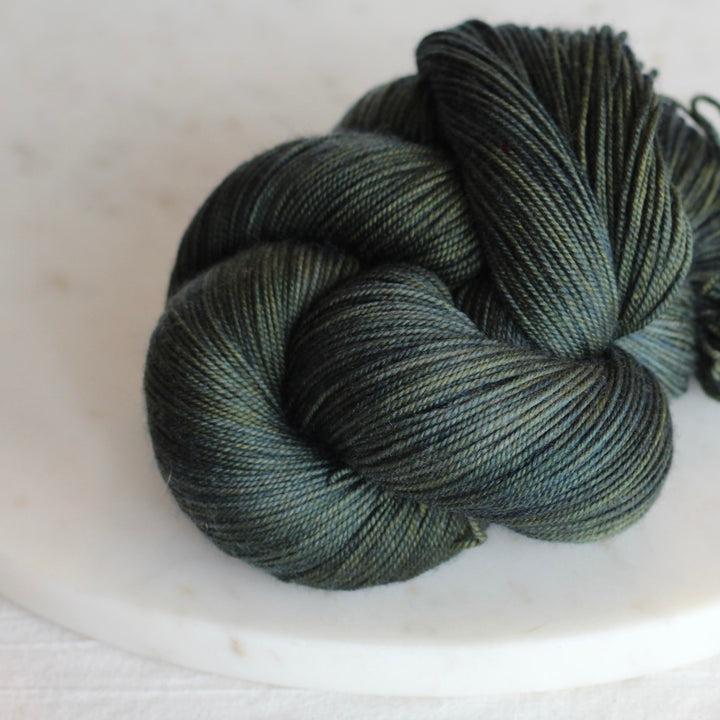 Deep pine green yarn on marble plate
